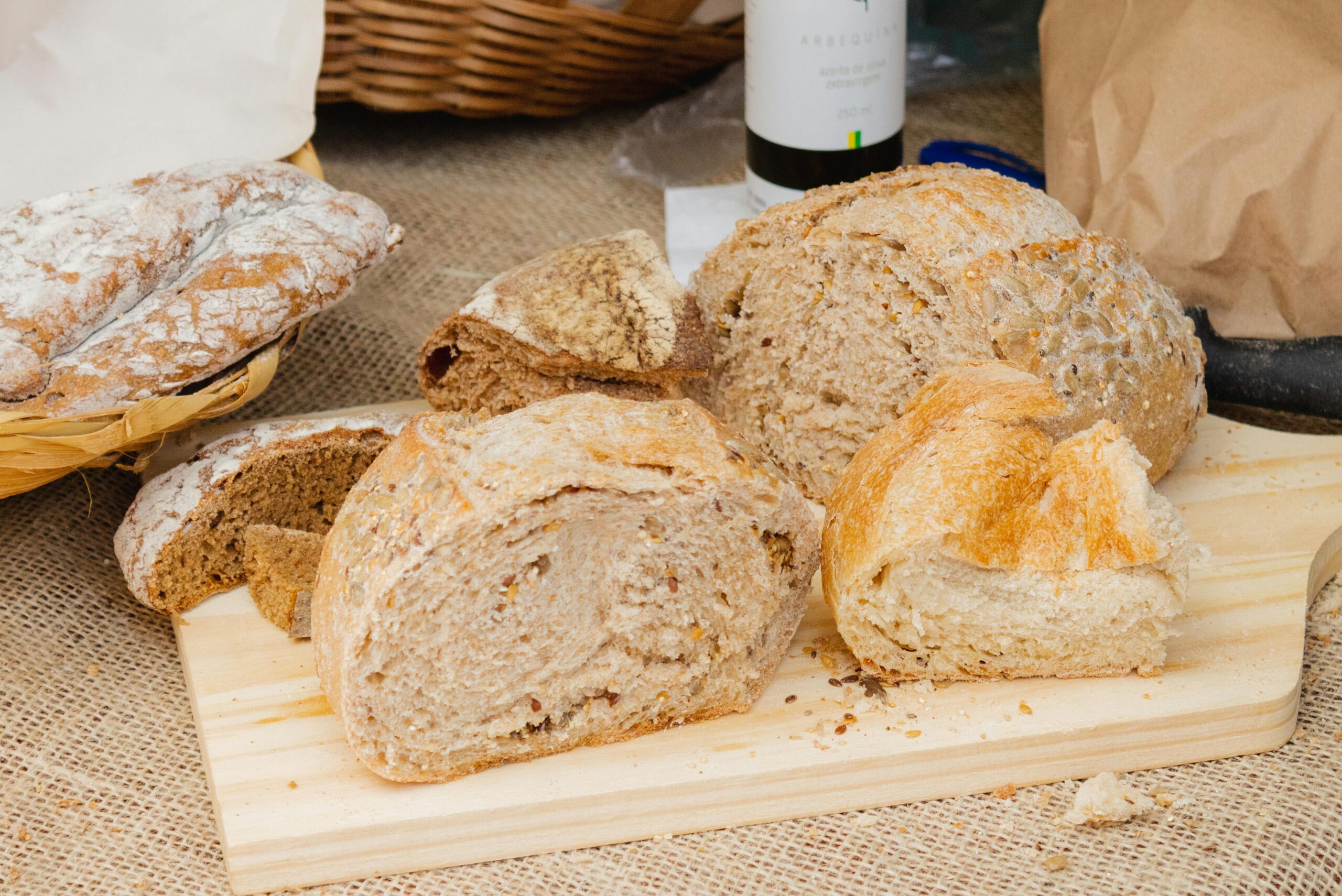 A variety of fresh artisan breads on a wooden board, displayed with a rustic style.