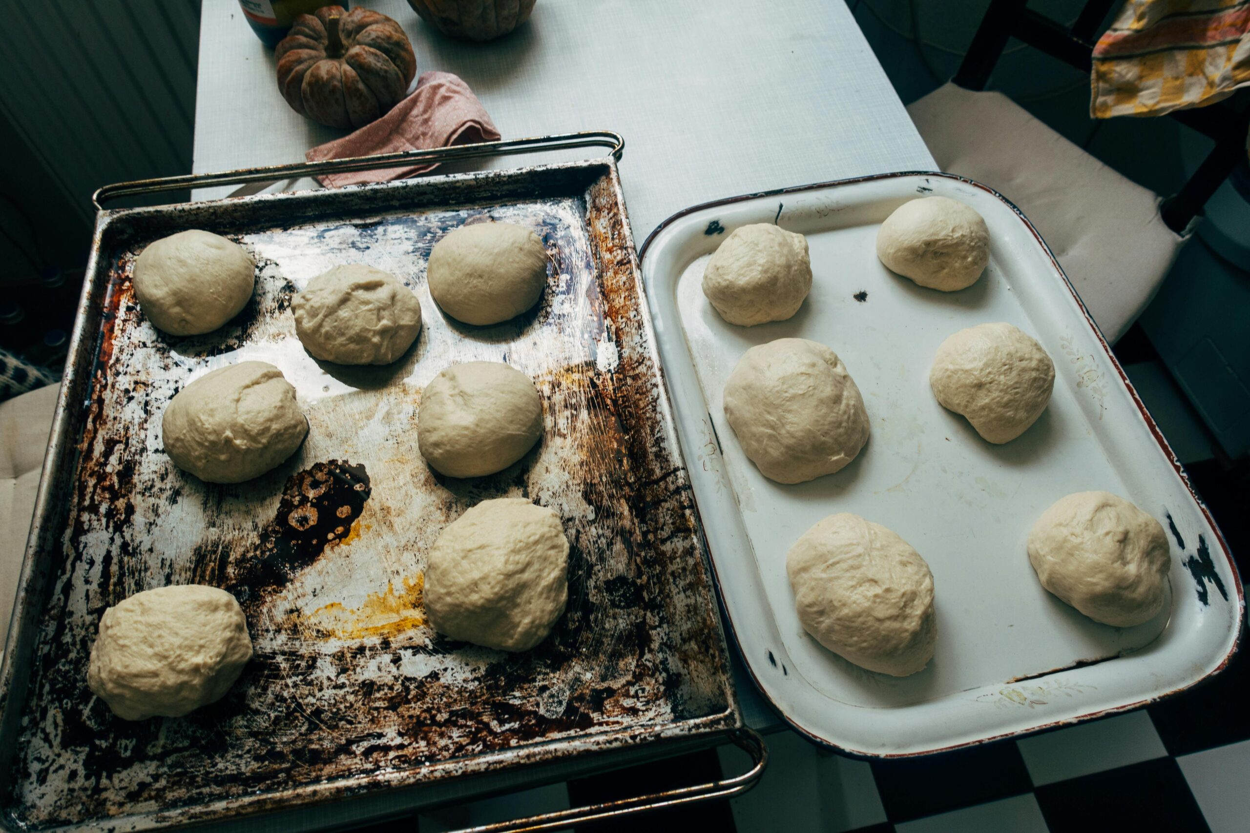 Homemade dough balls rising on rustic trays, ready for baking.